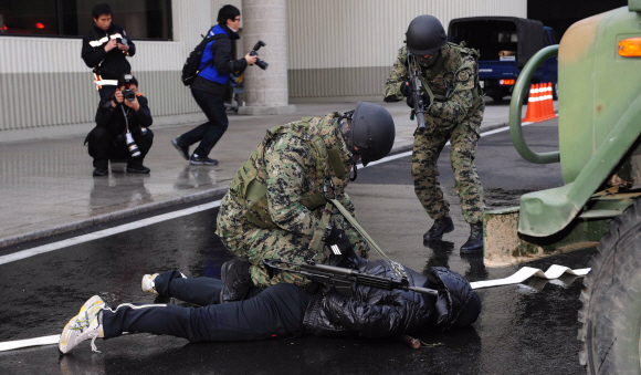 9일 김포공항 국제선청사에서 열린 서울 핵안보정상회의 대비 방사능 테러 대응훈련에서 군 특공대가 방사성 폭발물을 터뜨린 후 도망가던 범인을 제압, 검거하고 있다.