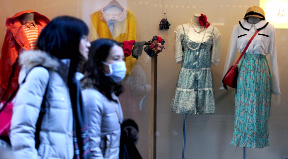 아침기온이 영하로 떨어진 11일 오전 서울 중구 명동에서 봄옷이 전시된 쇼윈도 앞을 시민들이 지나가고 있다. 박지환 popocar@seoul.co.kr