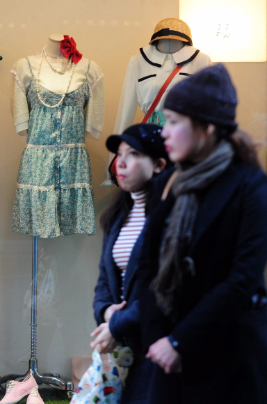 아침기온이 영하로 떨어진 11일 오전 서울 중구 명동에서 봄옷이 전시된 쇼윈도 앞을 시민들이 지나가고 있다. 박지환 popocar@seoul.co.kr