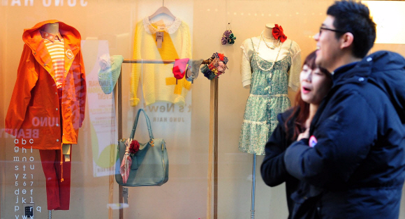 아침기온이 영하로 떨어진 11일 오전 서울 중구 명동에서 봄옷이 전시된 쇼윈도 앞을 시민들이 지나가고 있다. 박지환 popocar@seoul.co.kr