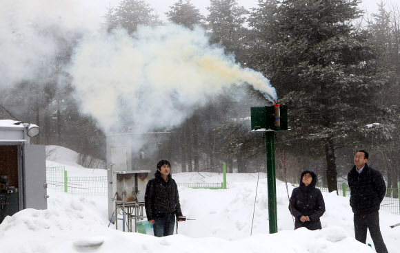 기상청 연구원들이 지난 9일 구름씨앗으로 쓰이는 요오드화은을 산의 경사면을 타고 부는 바람을 이용해 구름 속으로 올려 보내는 인공강설 실험 과정을 선보이고 있다.  연합뉴스