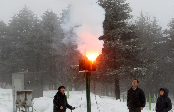 기상청 연구원들이 지난 9일 구름씨앗으로 쓰이는 요오드화은을 산의 경사면을 타고 부는 바람을 이용해 구름 속으로 올려 보내는 인공강설 실험 과정을 선보이고 있다. 연합뉴스