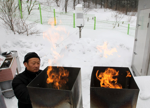 기상청 연구원들이 지난 9일 구름씨앗으로 쓰이는 요오드화은을 산의 경사면을 타고 부는 바람을 이용해 구름 속으로 올려 보내는 인공강설 실험 과정을 선보이고 있다. 연합뉴스