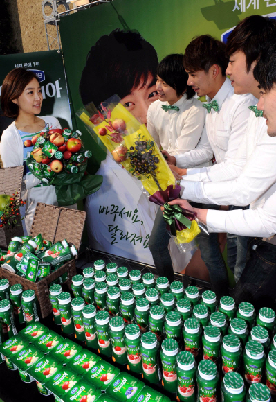 다논의 액티비아 신제품 4종 출시 행사에서 남성 모델들이 여성 고객에게 과일을 선물하고 있다.  류재림기자 jawoolim@seoul.co.kr