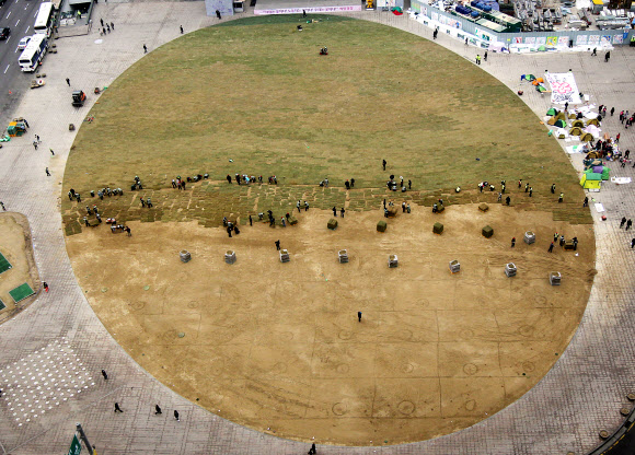 14일 오후 시청 앞 서울광장에서 서울시 관계자들이 새봄을 맞아 잔디를 교체하고 있다. 연합뉴스