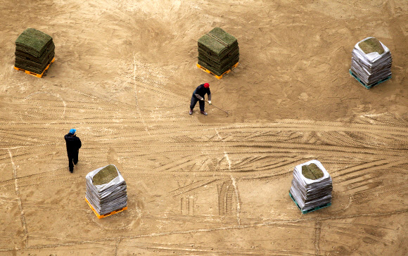 14일 오후 시청 앞 서울광장에서 서울시 관계자들이 새봄을 맞아 잔디를 교체하고 있다. 연합뉴스