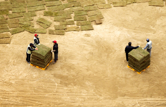 14일 오후 시청 앞 서울광장에서 서울시 관계자들이 새봄을 맞아 잔디를 교체하고 있다. 연합뉴스