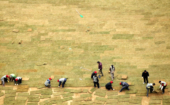 14일 오후 시청 앞 서울광장에서 서울시 관계자들이 새봄을 맞아 잔디를 교체하고 있다. 연합뉴스