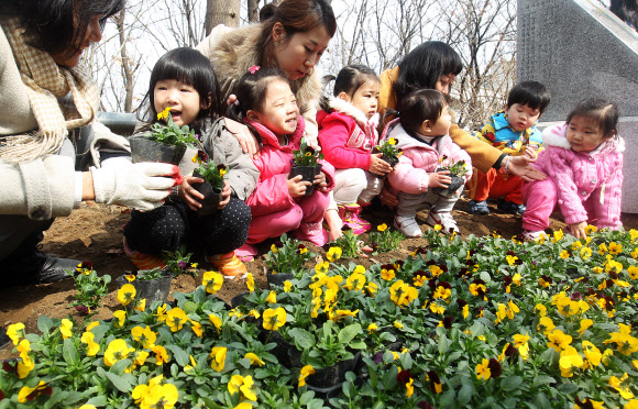 19일 오전 서울 서초구 방배동 도구로변에서 열린 ‘아름다운 꽃길 가꾸기’ 행사에서 어린이들이 꽃을 심고 있다.  연합뉴스