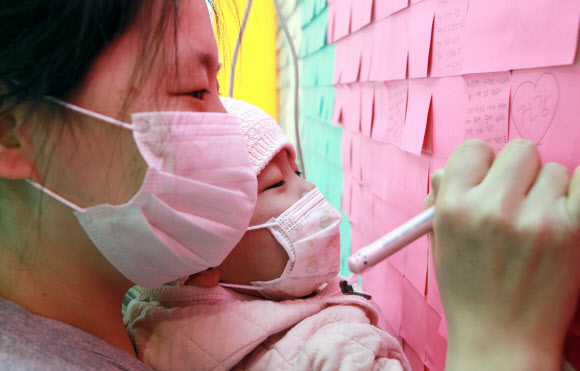 20일 오전 서울시 강남구 일원동 삼성서울병원에서 환자들이 빠른 쾌유를 기원하는 메시지를 벽면에 부착된 포스트잇에 적고 있다. 연합뉴스