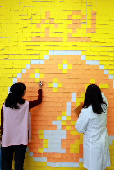 20일 오전 서울시 강남구 일원동 삼성서울병원에서 의사와 환자들이 빠른 쾌유를 기원하는 메시지를 벽면에 부착된 포스트잇에 적고 있다.