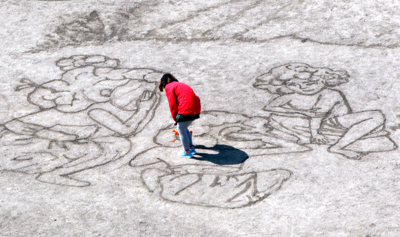 대한적십자사와 서울시립대학교 미술대학생 7명들이 ‘세계 물의 날’을 맞아 21일 서울 송파구 탄천 축구장에서 물로 신윤복의 ‘단오풍정’을 그려내고 있다.  연합뉴스