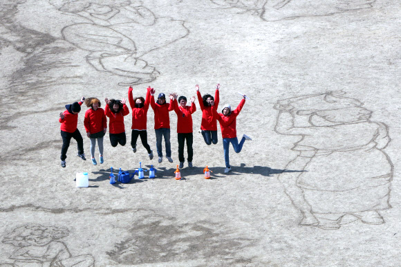 대한적십자사와 서울시립대학교 미술대학생 7명들이 ‘세계 물의 날’을 맞아 21일 서울 송파구 탄천 축구장에서 물로 신윤복의 ‘단오풍정’을 그려내고 있다.  연합뉴스