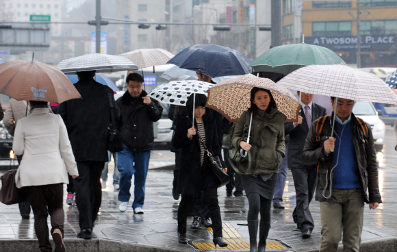 봄을 재촉하는 비가 내린 23일 오전 시민들이 우산을 들고 광화문을 지나고 있다. 도준석기자 pado@seoul.co.kr