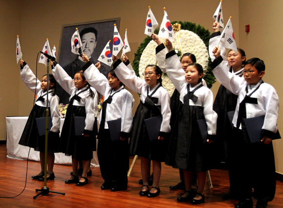 26일 서울 중구 남대문로 5가 안중근의사기념관에서 열린 안중근의사 순국 102주기 추모식에서 어린이합창단원들이 추모가를 부르며 태극기를 흔들고 있다.  연합뉴스