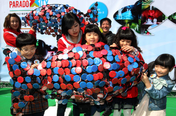 서울시청앞 광장에서 환경보호의 일환으로 개최한 “우정의 물고기” 희망 이벤트. 어린이들이 희망의 메시지를 적은 뱃지를 물고기 조형물에 부착하고 있다. 연합뉴스