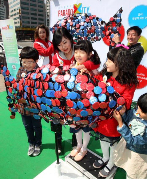 서울시청앞 광장에서 환경보호의 일환으로 개최한 “우정의 물고기” 희망 이벤트. 어린이들이 희망의 메시지를 적은 뱃지를 물고기 조형물에 부착하고 있다. 연합뉴스