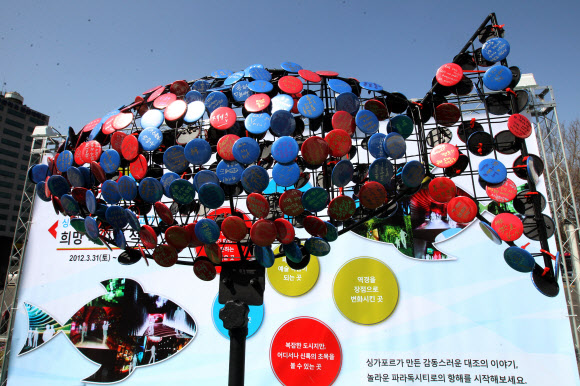 서울시청앞 광장에서 환경보호의 일환으로 개최한 “우정의 물고기” 희망 이벤트. 어린이들이 희망의 메시지를 적은 뱃지를 물고기 조형물에 부착하고 있다. 연합뉴스