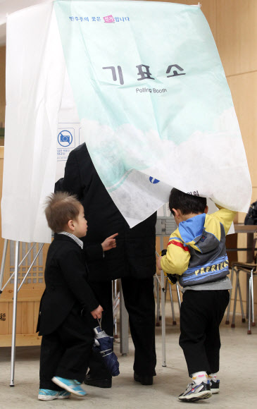 제19대 국회의원 선거일인 11일 오전 서울 마포구 노고산동 신촌 성결교회 투표소에서 할머니를 따라온 아이들이 기표소 안을 들여다 보고 있다.