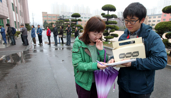 제19대 국회의원 선거일인 11일 오전 인천시 남구 용현동 용현여중에 마련된 용현5동 제6투표소 앞에서 투표를 마친 한 유권자가 지상파 방송3사 출구조사에 응하고 있다.