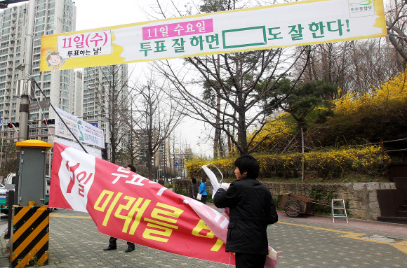 송파구청 주택관리과 직원들이 12일 오전 서울 송파구 오금동 개롱역 사거리에 설치된 제19대 국회의원선거 현수막들을 수거 하고 있다. 수거된 현수막은 농민들에게 제공되어 다양하게 활용 된다. 연합뉴스