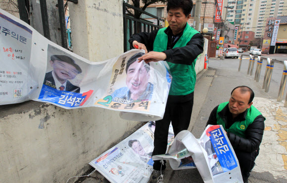 12일 오후 인천시 남동구 만수동에서 남동구 새마을회 회원들이 제19대 국회의원 선거벽보를 철거하고 있다. 연합뉴스