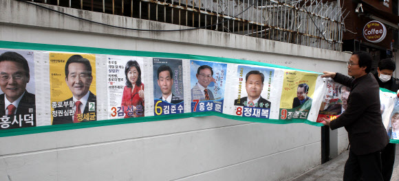 19대 국회의원 선거가 끝난 후 12일 서울 종로구 가회동사무소 직원들이 주택가에 설치했던 선거 벽보를 철거하고 있다. 연합뉴스