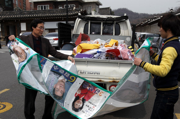 19대 국회의원 선거가 끝난 후 12일 서울 종로구 가회동사무소 직원들이 주택가에 설치했던 선거 벽보를 철거한 후 수거하고 있다. 연합뉴스