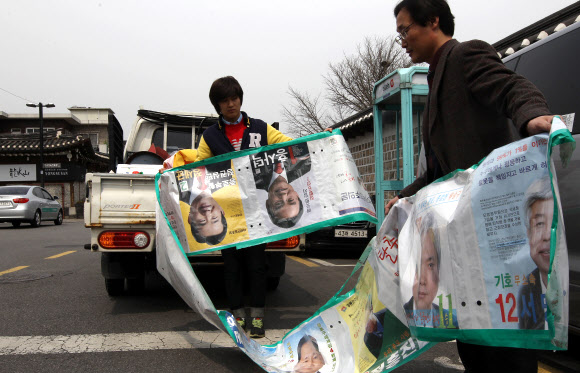 19대 국회의원 선거가 끝난 후 12일 서울 종로구 가회동사무소 직원들이 주택가에 설치했던 선거 벽보를 철거하고 있다. 연합뉴스