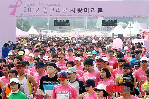 15일 오전 부산 해운대구 수영만 요트경기장에서 열린 ‘2012 핑크리본 사랑 마라톤 대회’에 참가한 시민 5000여 명이 유방암 예방을 뜻하는 핑크색 옷을 입고 출발신호에 맞춰 달리고 있다.