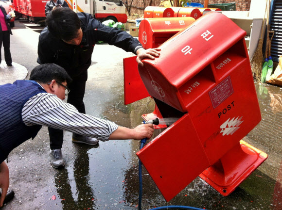 서울강남우체국 집배원들이 19일 오후 우체통 청소를 하고 있다. 이날 집배원들은 길거리 우체통이 파손될 경우에 대비하여 우체국에 보관 중인 우체통들을 꺼내 일제히 청소하고 거리에 설치된 우체통의 먼지도 깨끗이 닦았다. 연합뉴스
