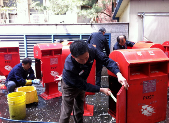 서울강남우체국 집배원들이 19일 오후 우체통 청소를 하고 있다. 이날 집배원들은 길거리 우체통이 파손될 경우에 대비하여 우체국에 보관 중인 우체통들을 꺼내 일제히 청소하고 거리에 설치된 우체통의 먼지도 깨끗이 닦았다. 연합뉴스