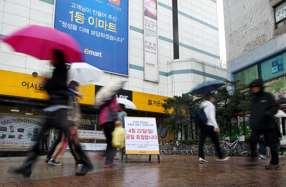 대형마트와 기업형 슈퍼마켓(SSM)의 의무휴업이 첫 시행된 22일 서울 강동구 이마트를 찾은 고객들이 휴점 안내문을 보며 발걸음을 옮기고 있다. 연합뉴스