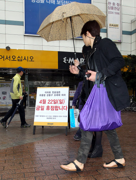 대형마트와 기업형 슈퍼마켓(SSM)의 의무휴업이 첫 시행된 22일 서울 강동구 이마트를 찾은 고객들이 휴점 안내문을 보며 발걸음을 옮기고 있다. 연합뉴스