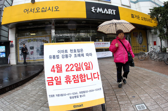 대형마트와 기업형 슈퍼마켓(SSM)의 의무휴업이 첫 시행된 22일 서울 강동구 이마트를 찾은 고객들이 휴점 안내문을 보며 발걸음을 옮기고 있다. 연합뉴스