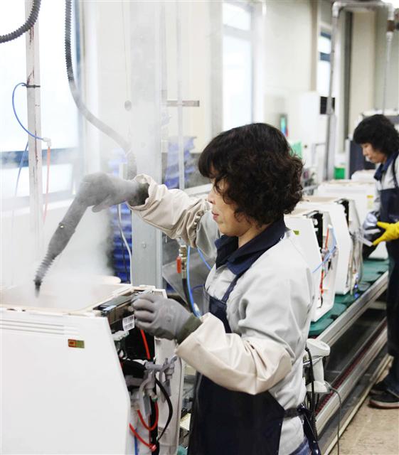경기 포천에 있는 웅진코웨이 리사이클링센터에서 한 직원이 반품된 제품의 외관을 꼼꼼하게 청소하고 있다. 웅진코웨이 제공