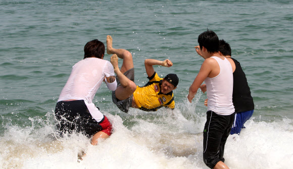 초여름 날씨를 보인 24일 강원 강릉시 경포 해변을 찾은 대학생들이 바다에 뛰어들어 성큼 다가온 무더위를 식히고 있다. 연합뉴스