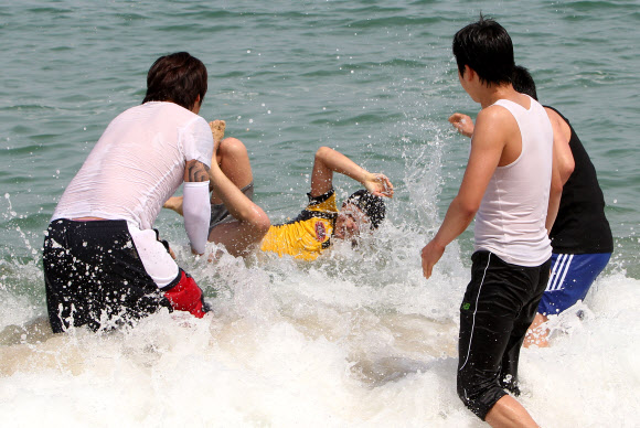 초여름 날씨를 보인 24일 강원 강릉시 경포 해변을 찾은 대학생들이 바다에 뛰어들어 성큼 다가온 무더위를 식히고 있다. 연합뉴스