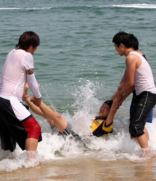 초여름 날씨를 보인 24일 강원 강릉시 경포 해변을 찾은 대학생들이 바다에 뛰어들어 성큼 다가온 무더위를 식히고 있다. 연합뉴스