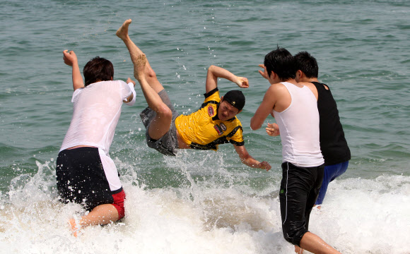 초여름 날씨를 보인 24일 강원 강릉시 경포 해변을 찾은 대학생들이 바다에 뛰어들어 성큼 다가온 무더위를 식히고 있다.  연합뉴스