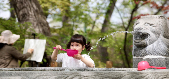 한 여름 날씨를 보인 경남 함양군 함양읍 상림공원을 찾은 여자아이가 샘물을 떠서 마시는 모습이 싱그럽다. 연합뉴스