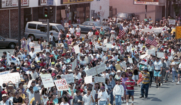 1992년 4월 미국 로스앤젤레스(LA)에서 일어난 흑인폭동이 진압된 직후 LA에 사는 한인 교포들이 태극기와 성조기를 들고 화합을 다짐하는 거리행진을 하고 있다. 서울신문 포토라이브러리