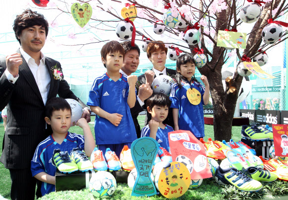 26일 오전 서울 용산 아이파크몰 옥상공원 풋살 경기장에서 열린 ‘아디다스 올인파크’ 오픈 행사에서 안정환 K리그 홍보대사(왼쪽부터), 정몽규 현대산업개발그룹 회장, 송종국 전 국가대표가 어린이들과 ‘축구사랑 소망나무’ 앞에서 기념촬영을 하고 있다.