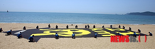 27일 오전 부산 해운대해수욕장 백사장에서 국제환경단체인 ‘그린피스’의 활동가들이 원전의 위험성을 알리는 대형 배너(가로 10m, 세로 30m)를 펼쳐보이고 있다.