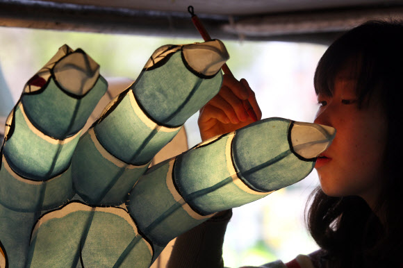 27일 청년회 법우들이 연등축제를 화려하게 수놓을 장엄등 제작에 바쁜 일손을 놀리고 있다.  연합뉴스