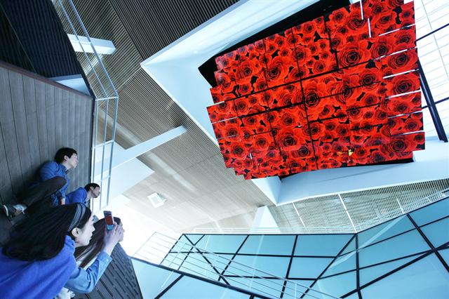 관람객들이 최근 전남 여수세계박람회 LG관 1층 로비에서 47인치 LED TV 54대가 구현하는 미디어 샹들리에의 장미꽃 미디어쇼를 감상하고 있다. LG 제공