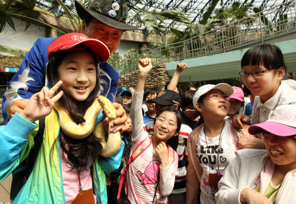 서울대공원과 현장체험학습 MOU를 체결한 금동초등학교 학생들이 30일 서울동물원 동양관에서 뱀을 목에걸고 기념촬영을 하며 즐거워하고 있다.   연합뉴스