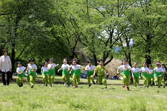 어린이날을 앞둔 2일 오후 서울 광진구 서울어린이대공원에서 건원초등학교 병설유치원생들이 밝게 웃으며 잔디밭을 뛰고 있다.  연합뉴스