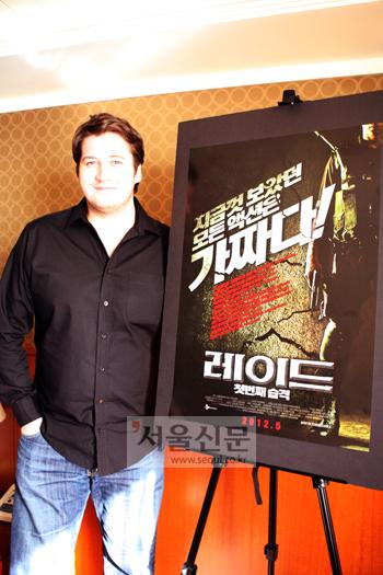 가렛 에반스 감독이 지난달 30일 서울 리베라 호델 룸에서 영화 ‘레이드’ 포스터 앞에서 포즈를 취하고 있다.