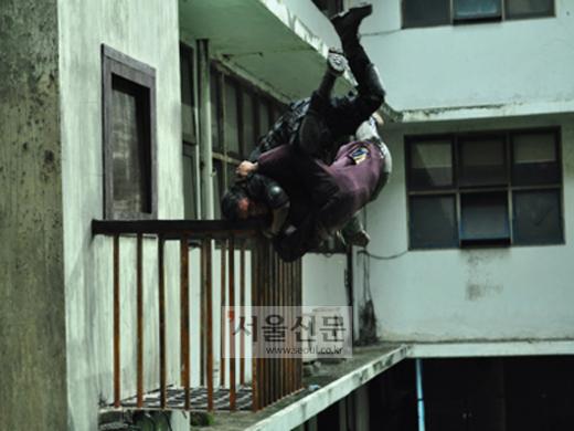 영화 ‘레이드’의 한 장면, 주연배우 이코가 다른 배우와 함께 추락 장면을 연기하고 있다.<br>